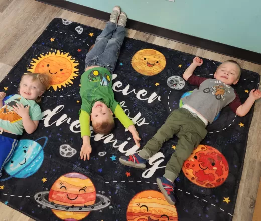 boys laying on a space rug
