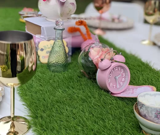 Table setup with grass, clocks and glasses