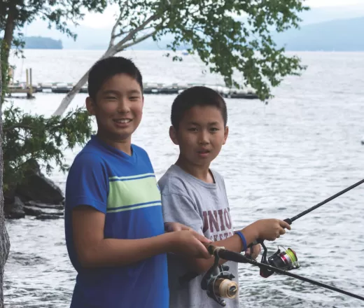 2 boys fishing at a lake